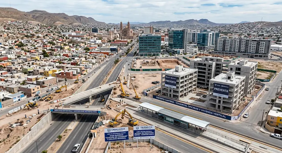 Vista aérea de desarrollo urbano con paso superior vehicular y edificios de vivienda vertical